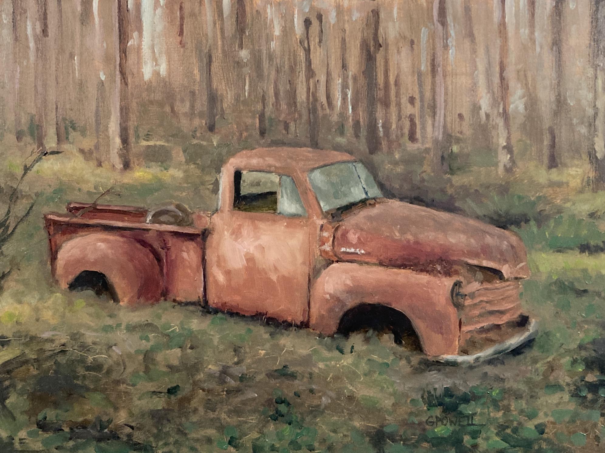 A rusty old 1950s Chevrolet sitting in a forest in dappled morning light.
